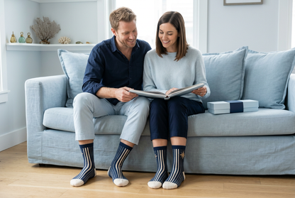Couple together viewing travel album wearing matching navy socks